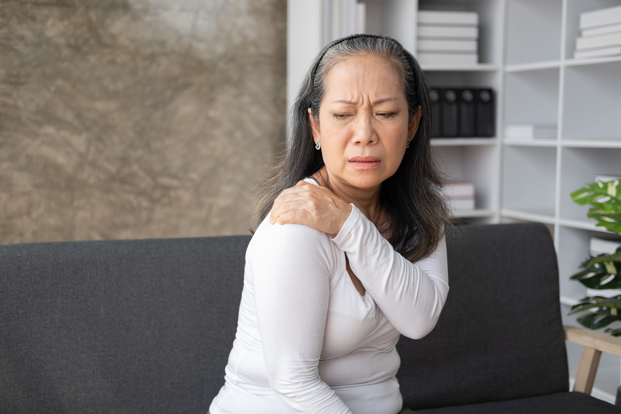 Middle aged asian woman suffers from shoulder joint pain or osteoporosis.